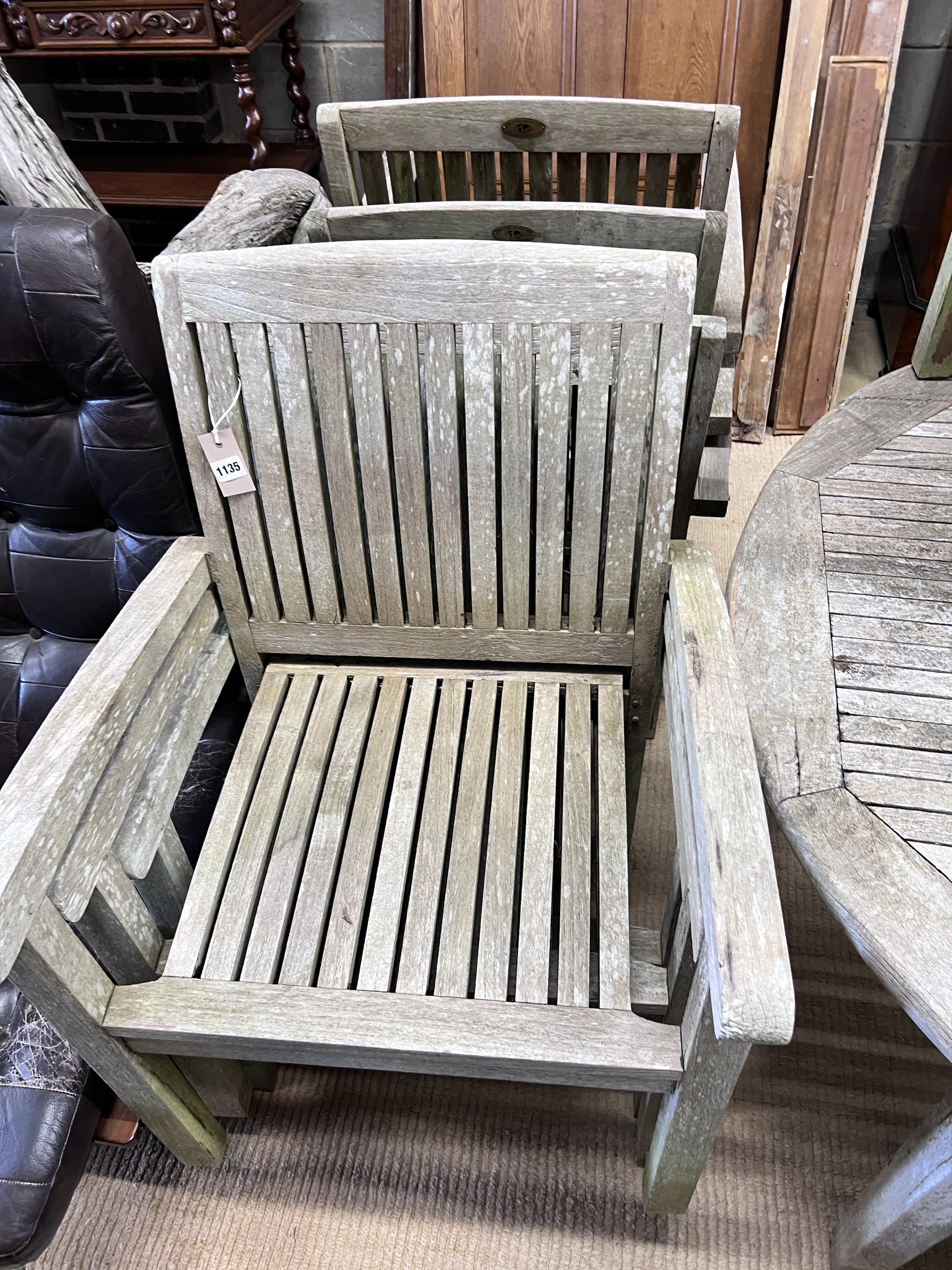 A Hard Woodstock Ltd. weathered teak extending garden table and eight matching stacking chairs